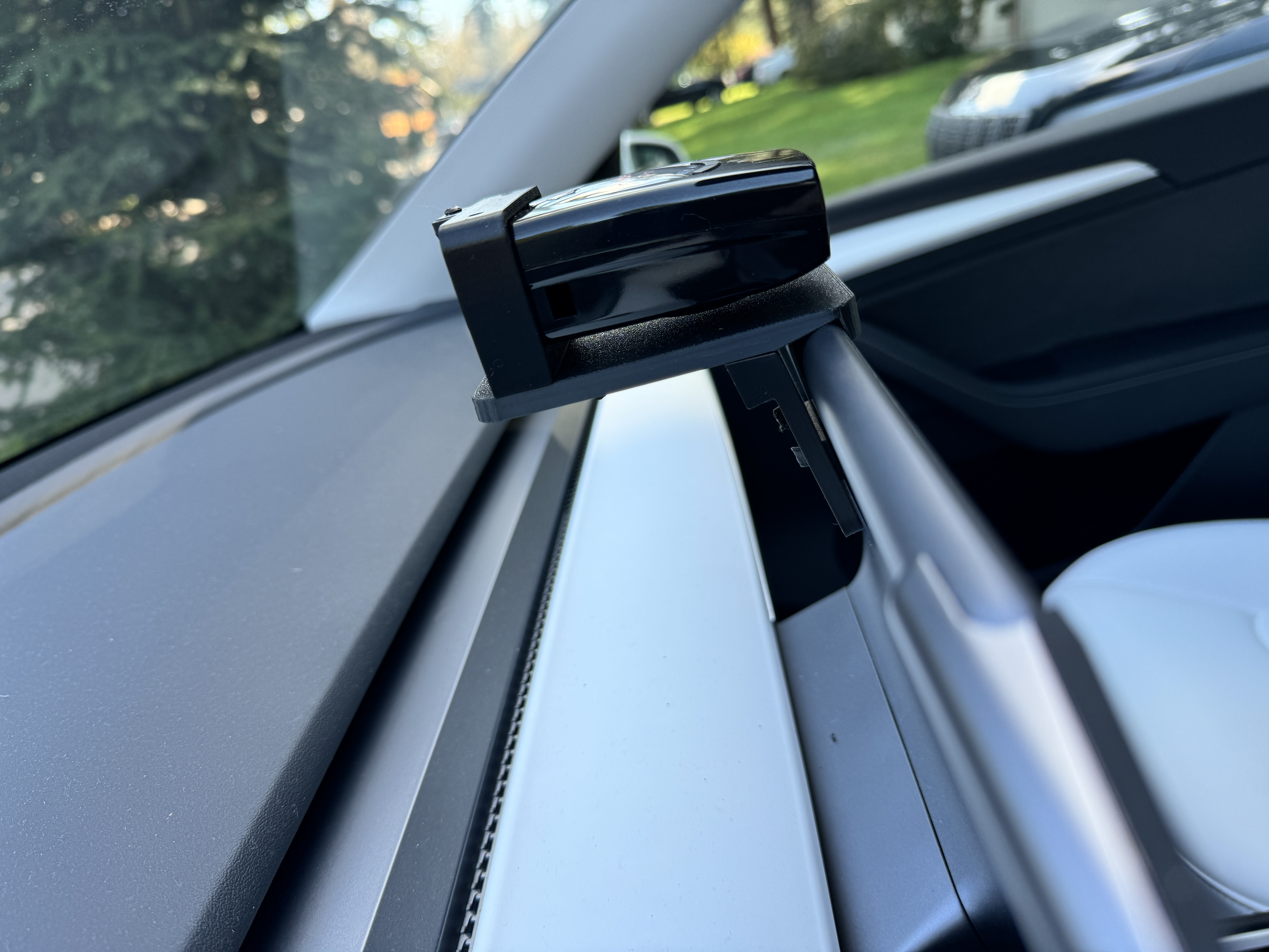 Side view of the Radenso Pro M installed in the bracket in a Tesla
