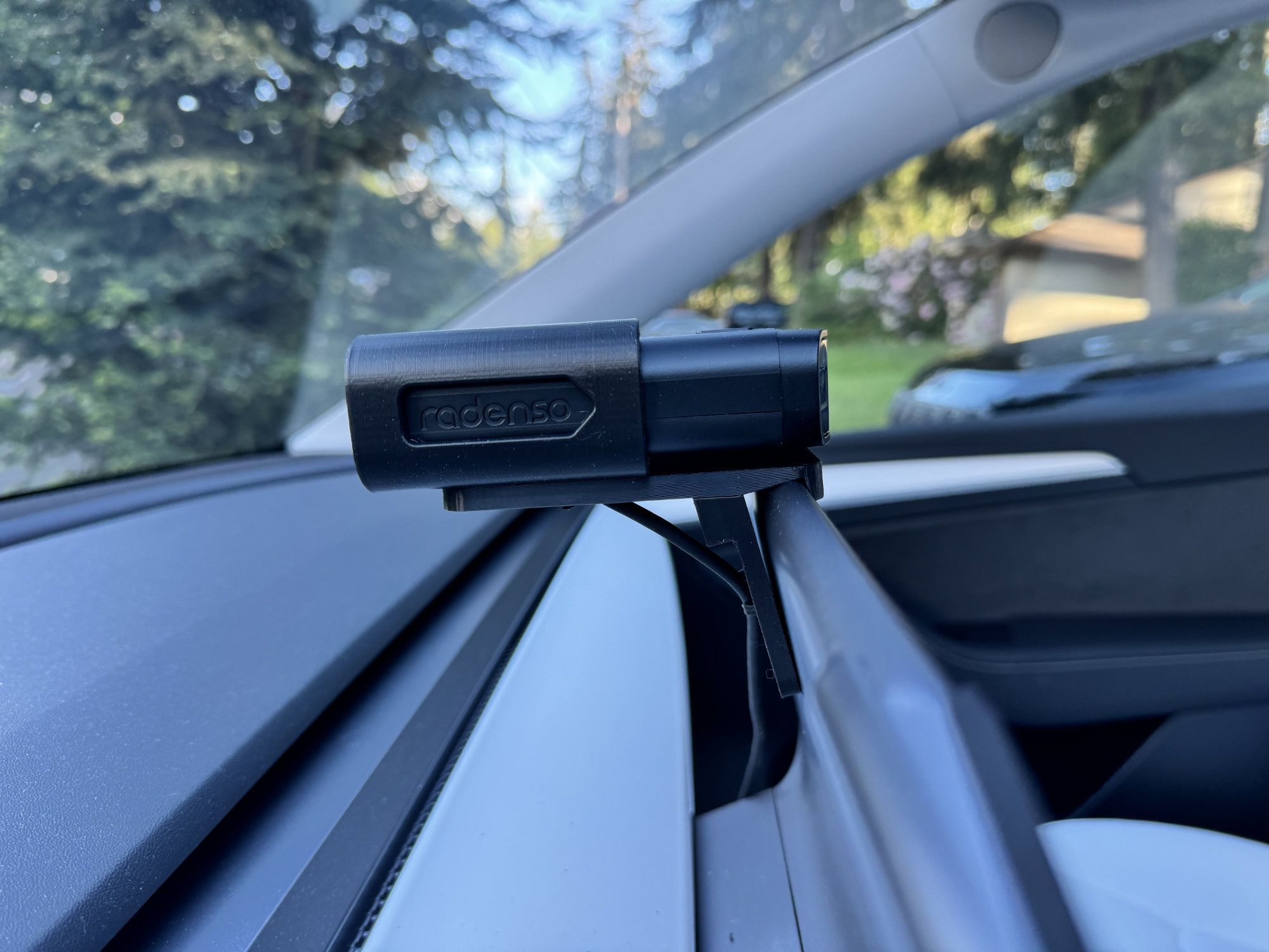 Side view of the Radenso DS1 installed in the bracket mounted in a Tesla